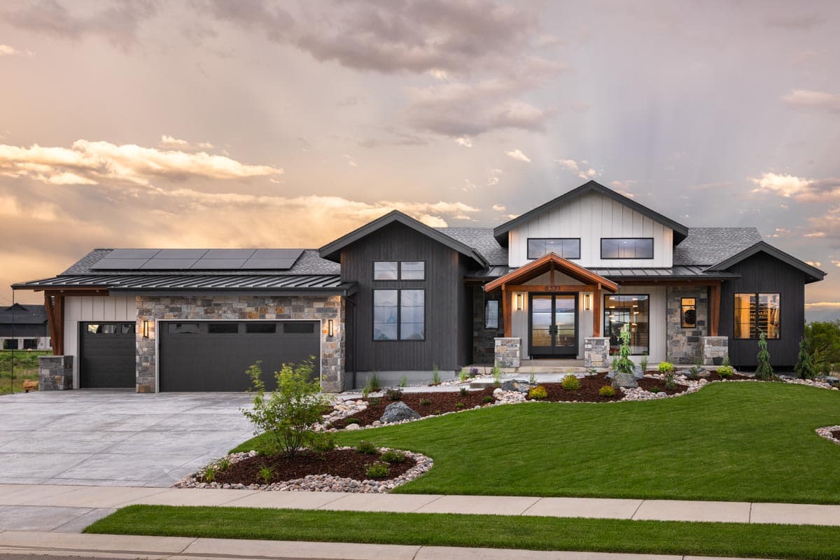 House plan exterior. Modern Farmhouse style with two stories, gabled roof, stone accents, a covered entry, and a side-entry garage.