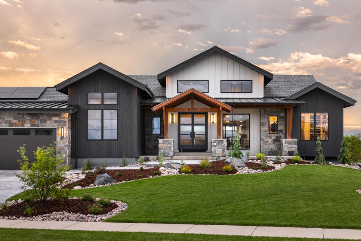 Modern house plan exterior with dark siding, stone accents, gabled roof, covered entry with wood beams, and attached garage.