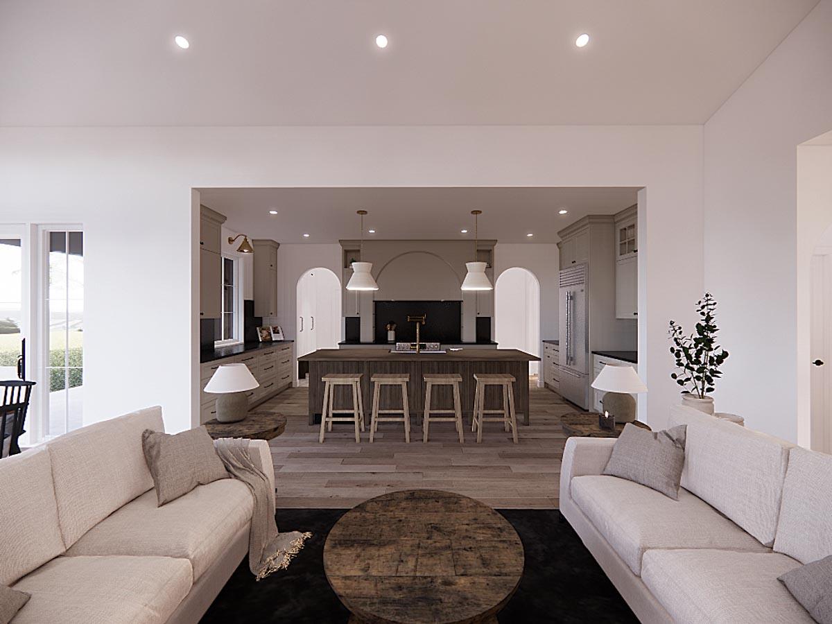 Spacious, open-concept living space with a kitchen visible in the background. Two sofas face each other, with a round coffee table on a dark rug.