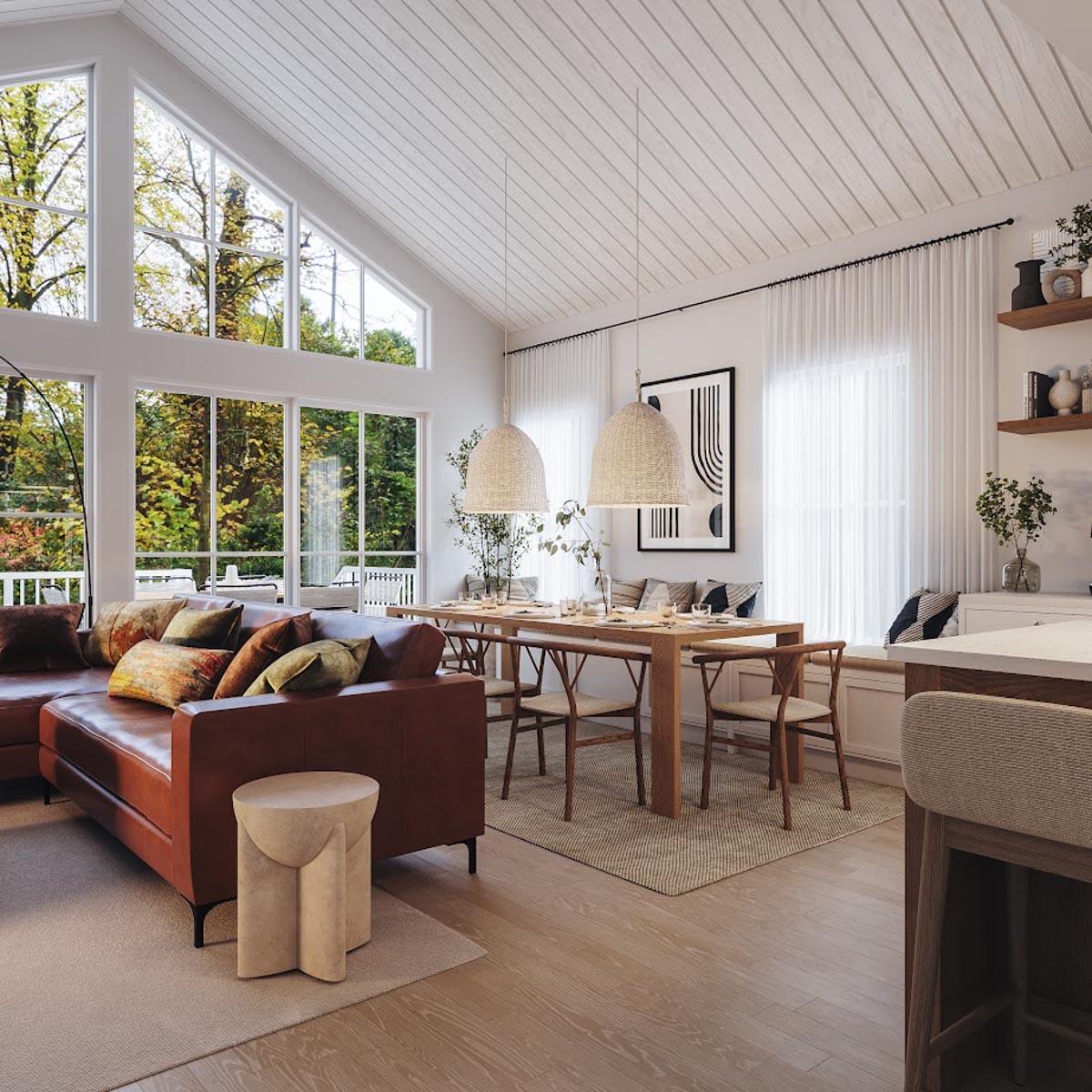 Open-concept living and dining area with vaulted ceilings, a large sectional sofa, and a long dining table beneath pendant lights.