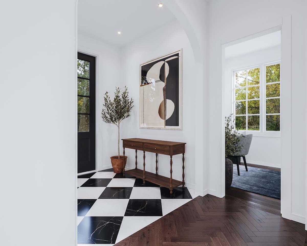 An entryway features a black and white checkered floor, a wooden console table, an abstract painting, and a small potted tree next to a black door.