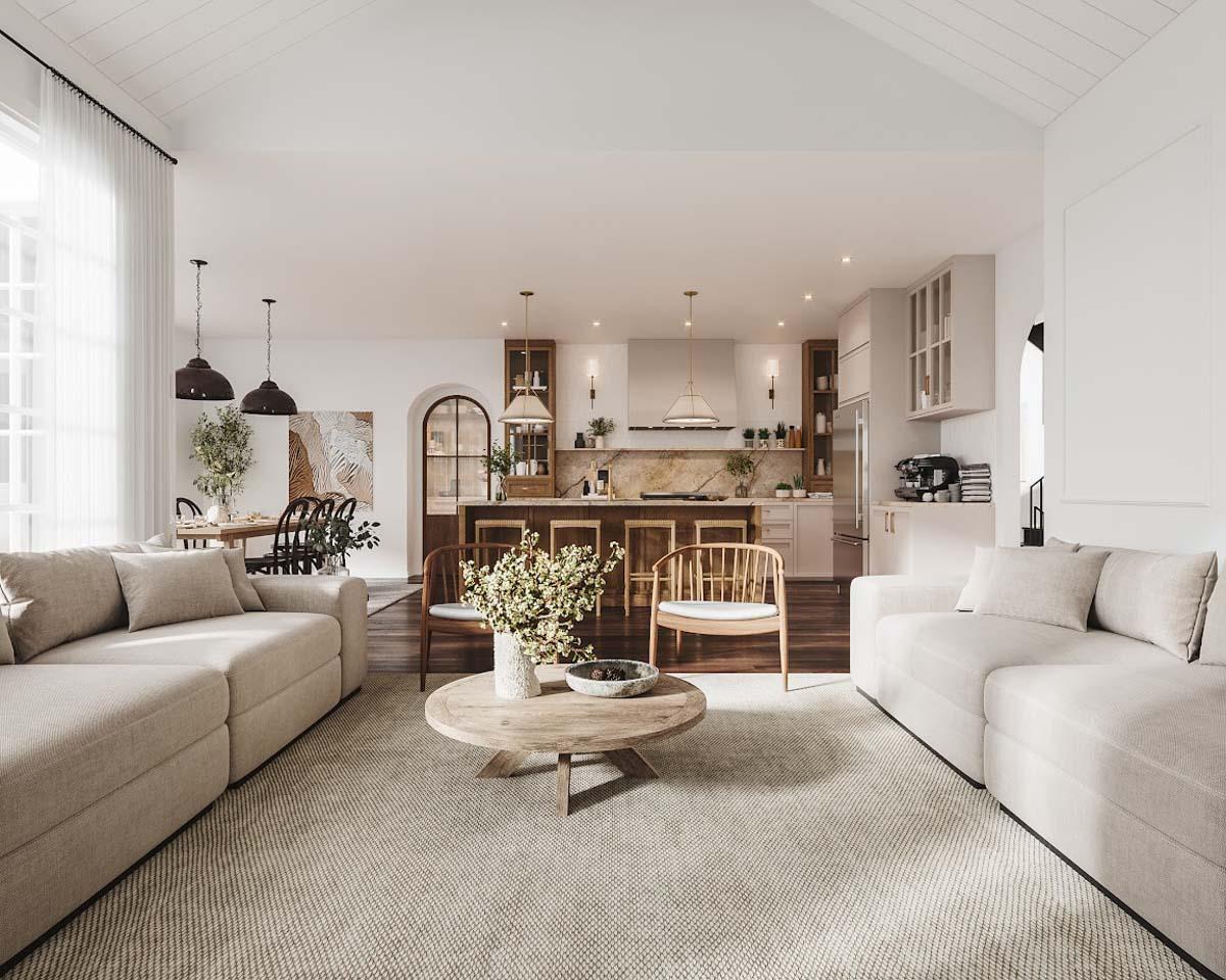 Spacious, open-concept living space with a kitchen and living room. Neutral colors and natural light create a warm atmosphere, with a large rug anchoring the space.