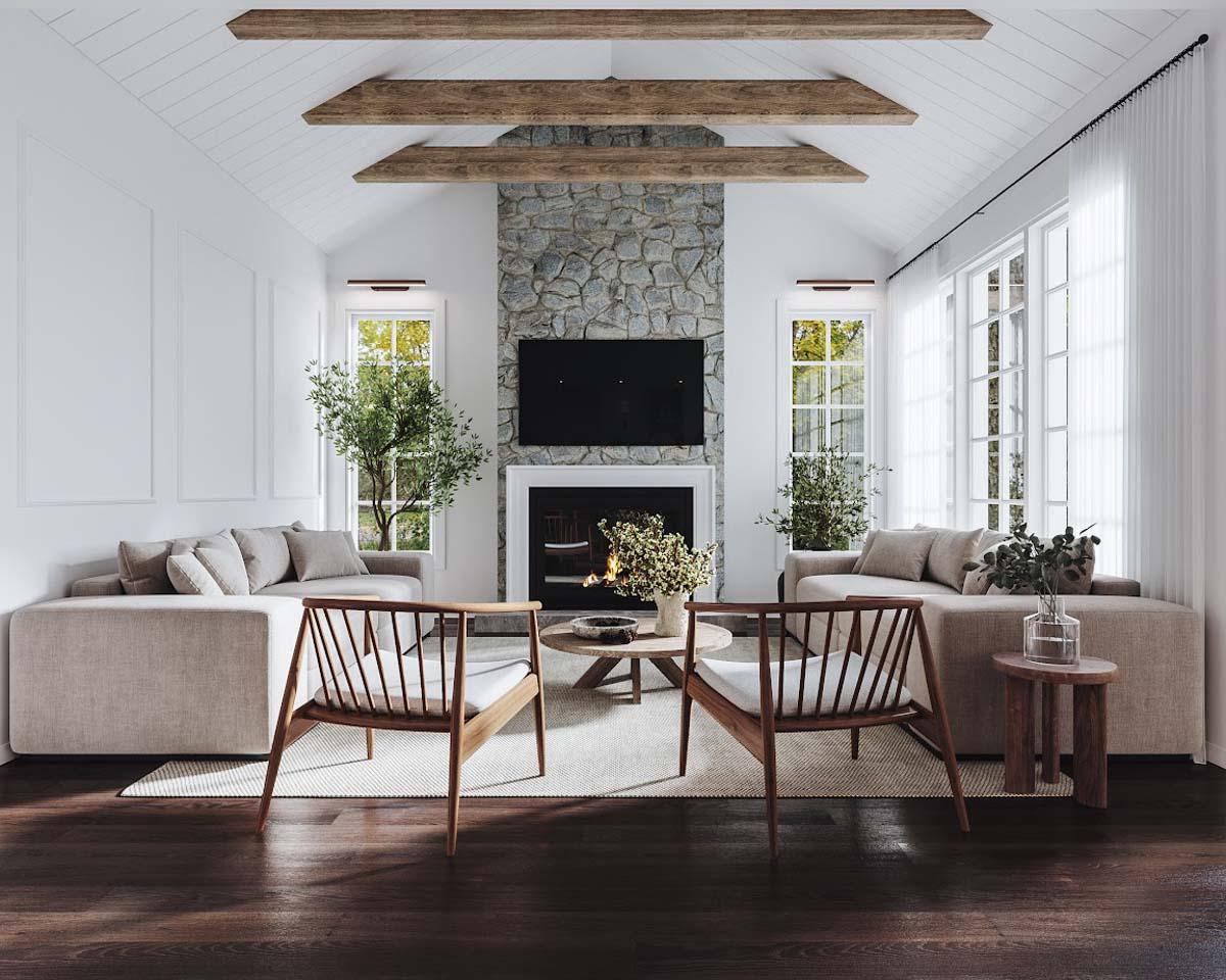 Spacious living room with stone fireplace, comfortable sofas, wooden chairs and ceiling beams. Large windows provide natural light to the space.