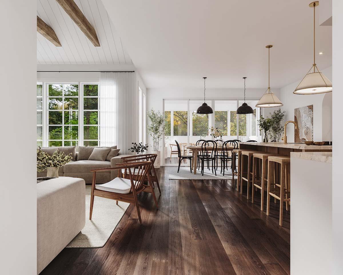 Spacious, sunlit open-plan living and dining area with hardwood floors, a large sofa, dining table, and kitchen island with bar seating.