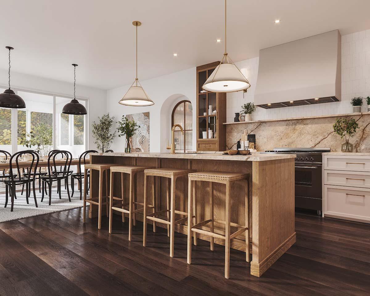 A modern kitchen with a wooden island and bar stools, pendant lights, and a dining area in the background with a long table and chairs.