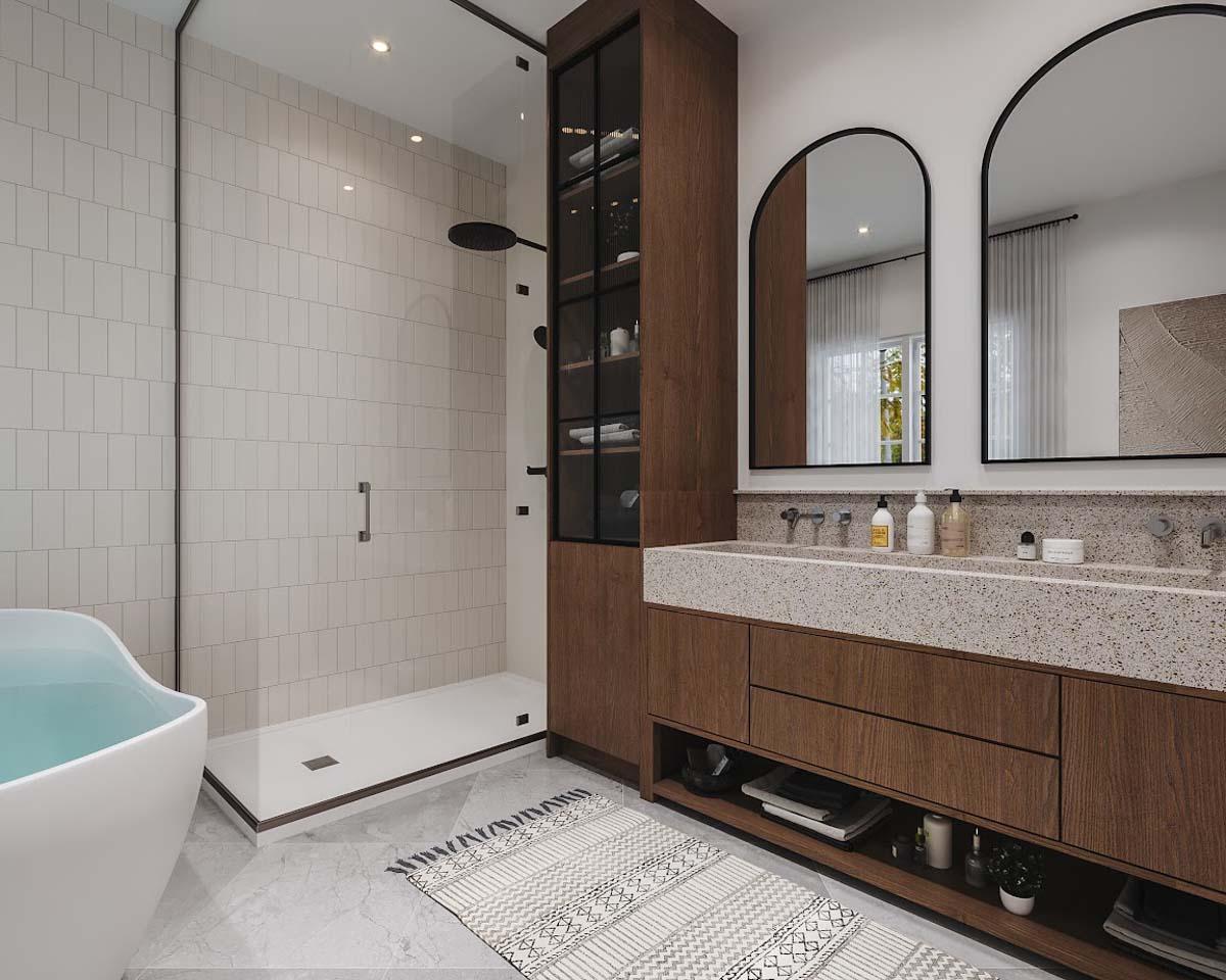 Modern bathroom featuring a glass shower, a soaking tub, and a double vanity with arched mirrors. Wooden cabinets and a patterned rug add warmth.