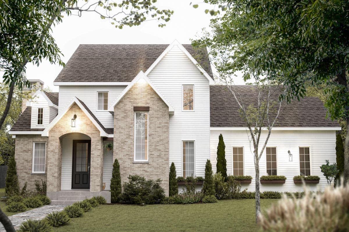 A two-story house with white siding and a brick facade. The home has a dark roof and is surrounded by trees and well-kept landscaping.