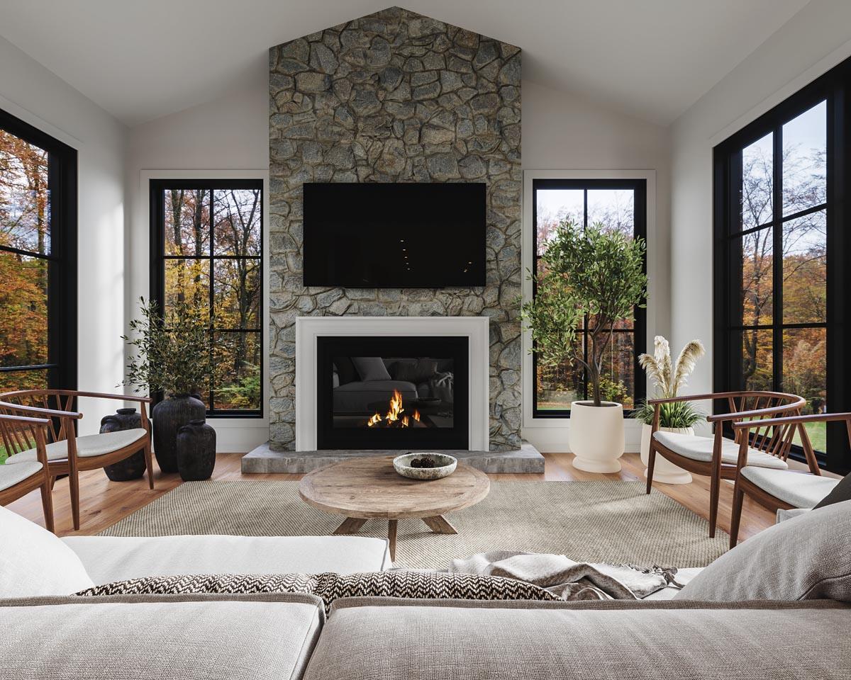 Great room with vaulted ceiling, stone fireplace, large windows, and seating area.