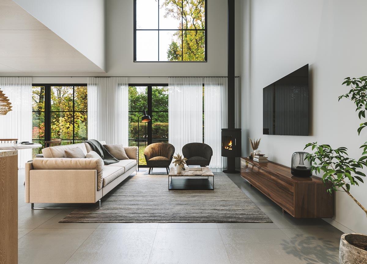 Open-concept living room with vaulted ceiling, fireplace, and large windows framing a wooded view.