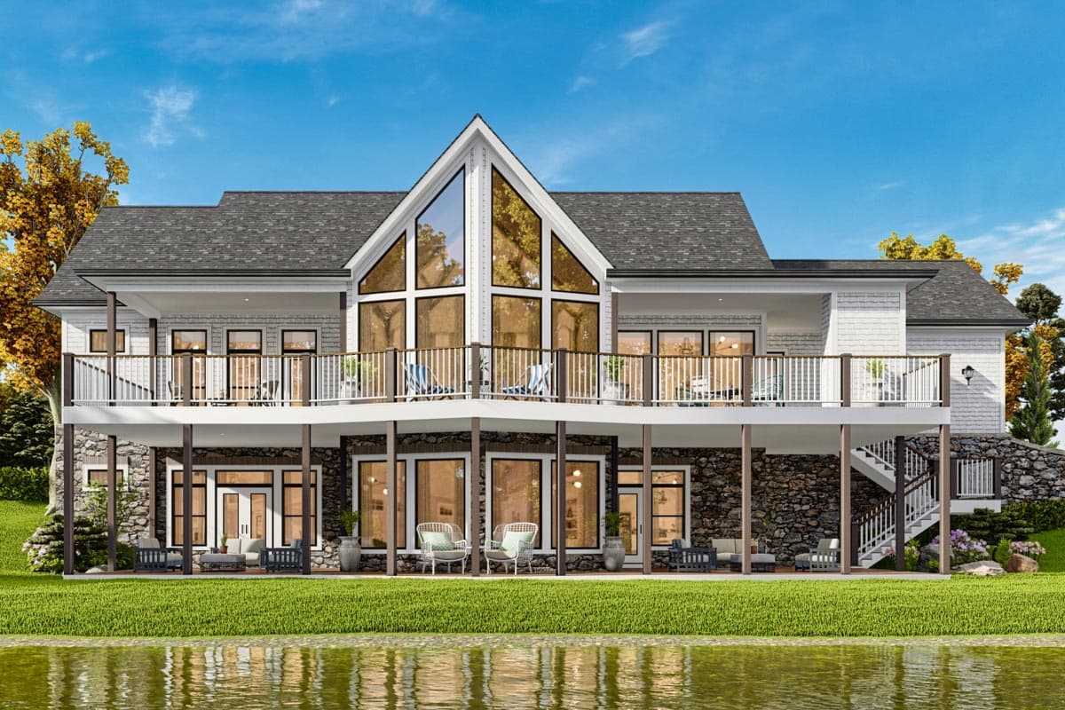 House plan exterior: Two-story home with large A-frame window, wraparound deck, and stone foundation.
