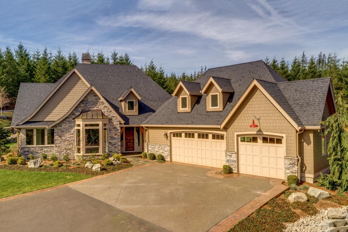 House plan exterior featuring a multi-level roof, stone accents, bay window, and a three-car garage.