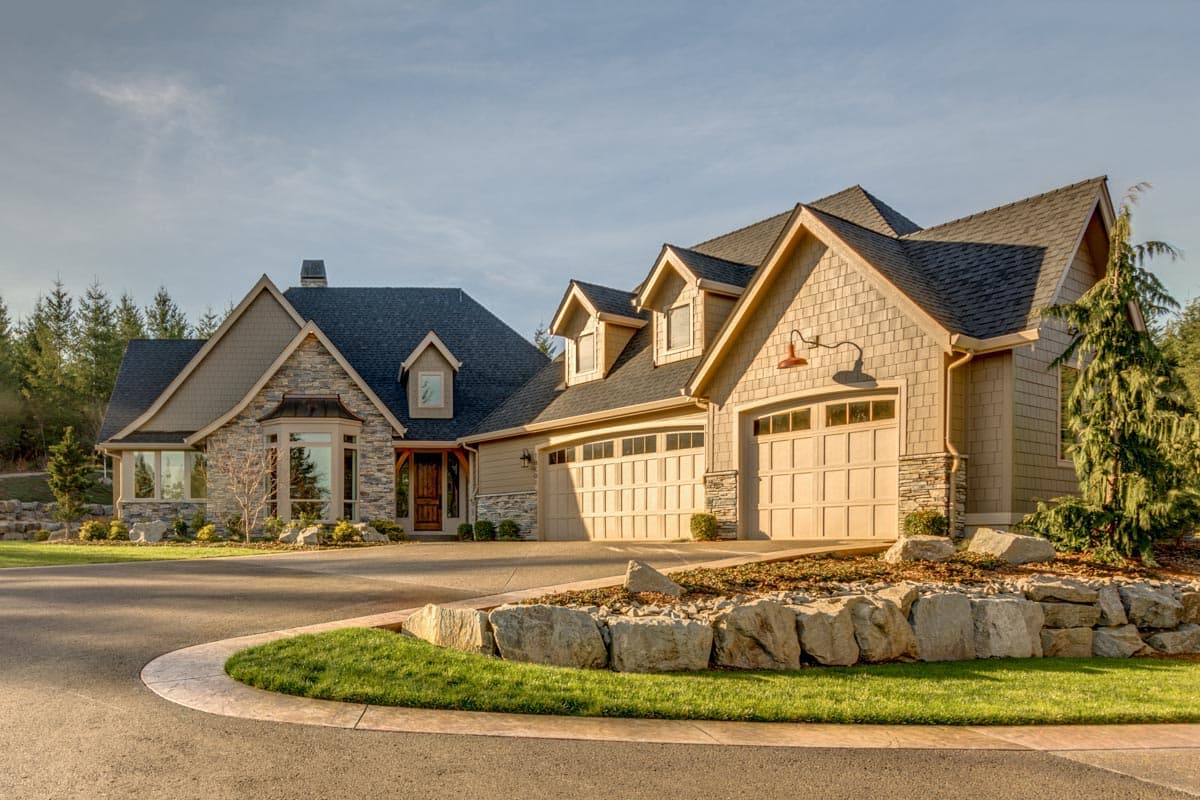 House plan exterior: Modern lodge style with stone accents, multiple gables, dormers, and a three-car garage.