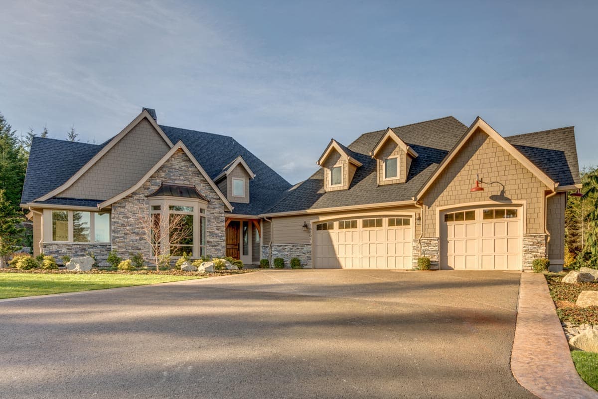 House plan exterior with stone accents, a bay window, dormers, and a three-car garage.