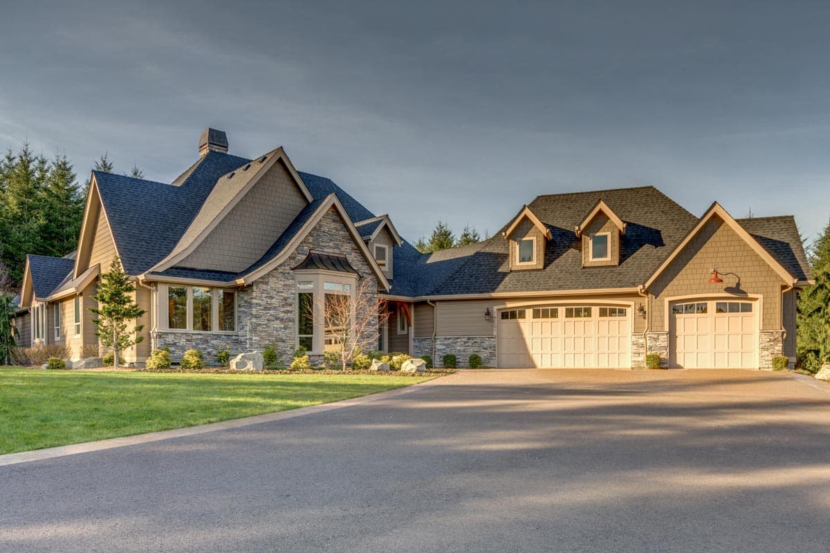 House plan exterior with stone accents, multiple gables, dormers, and a three-car garage.