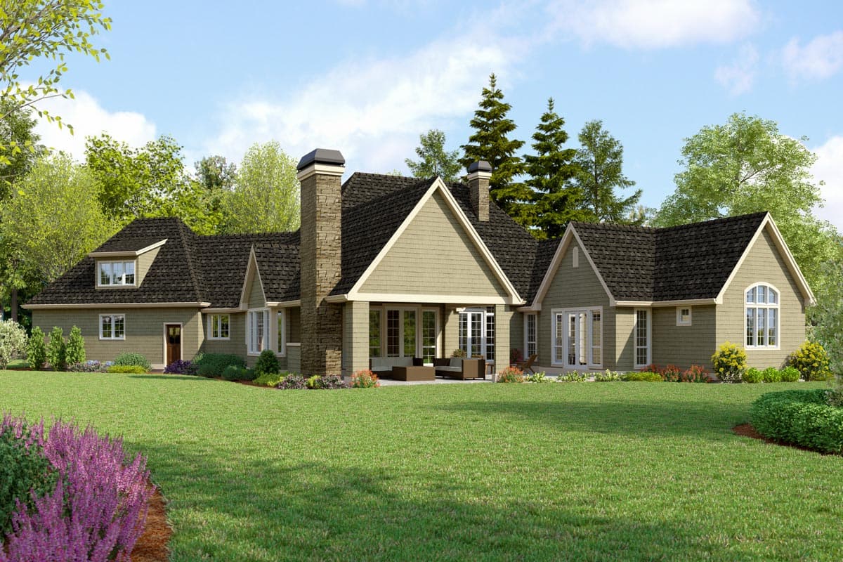 House plan exterior view of a tan, two-story home with gables, dormers, and a stone chimney.