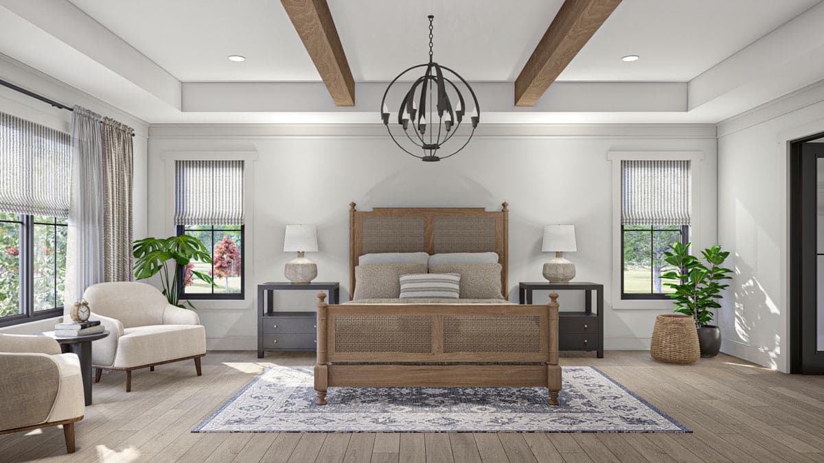 Primary bedroom with wood-beamed tray ceiling, king-size bed with rattan headboard, sitting area, and two windows.