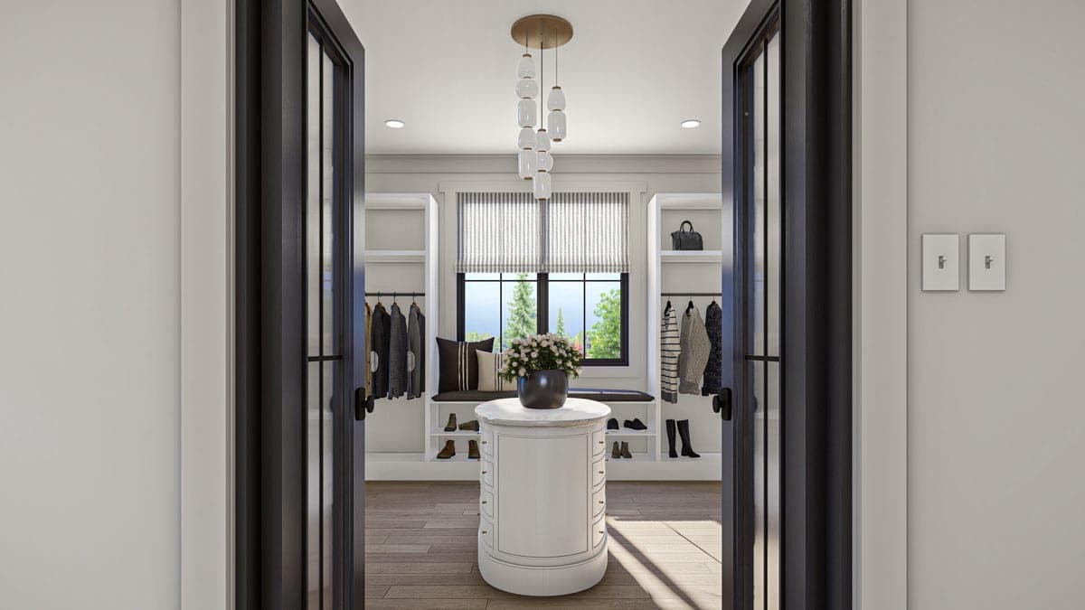 Walk-in closet with built-in shelving, hanging racks, center island, and window seating.