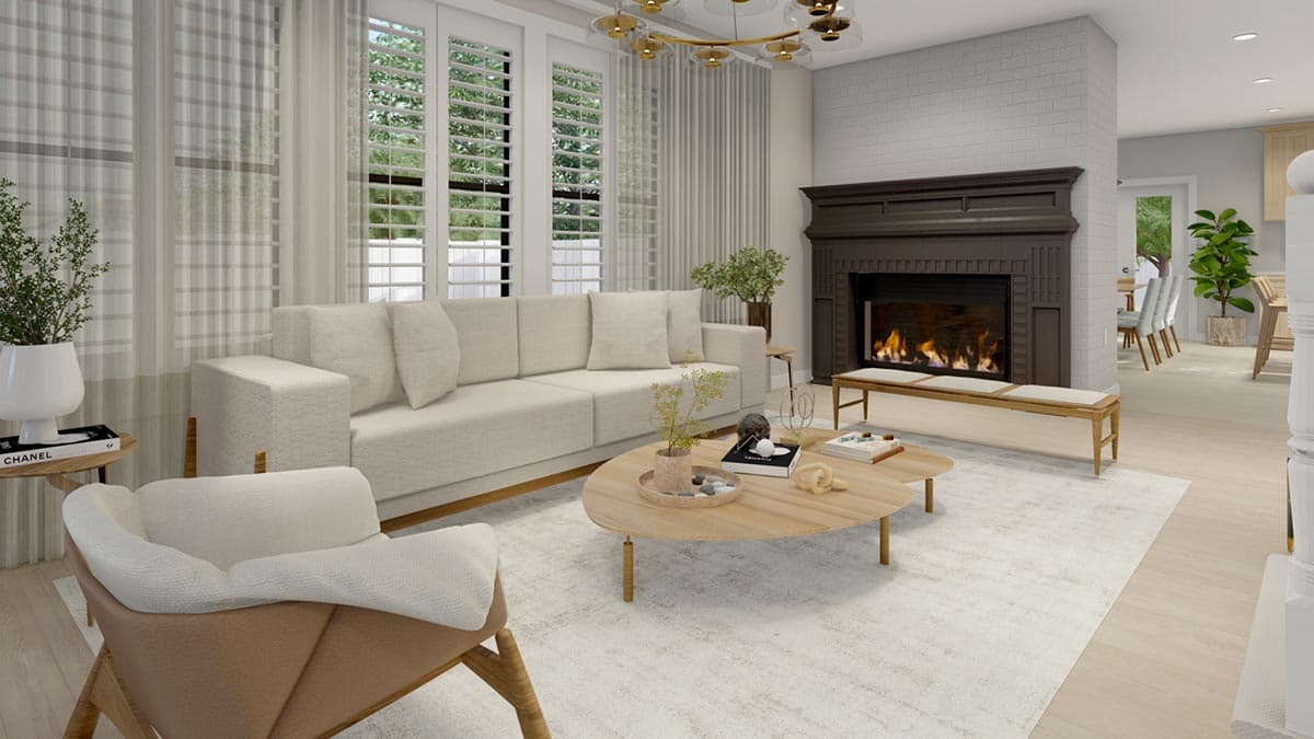 Living room with a neutral-toned sofa, fireplace, oval coffee table, and view of a dining area.