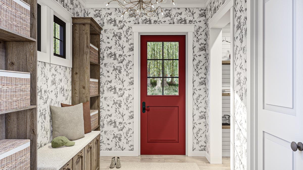 Mudroom with red dutch door, wood shelving, built-in bench, and patterned wallpaper.