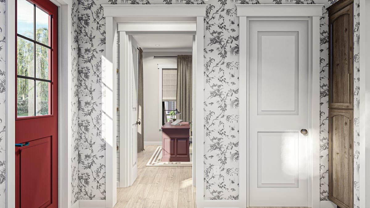 Interior view showing a hallway with a red Dutch door, a paneled door, and a glimpse into a room with a desk.