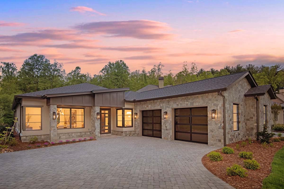 House plan exterior with stone veneer, flat roof, and two-car garage. Features include a covered entry and large windows. Single-story construction.
