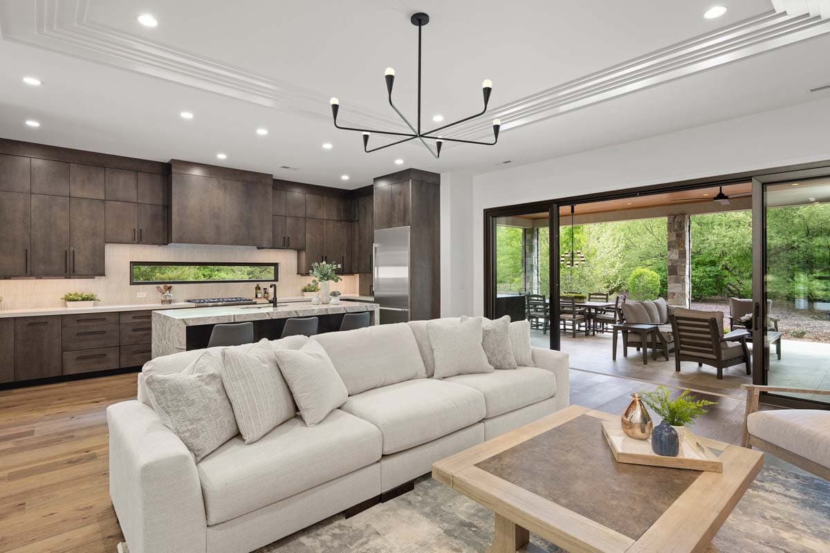 Open concept living area with a modern kitchen, large island, and access to an outdoor patio through sliding glass doors.