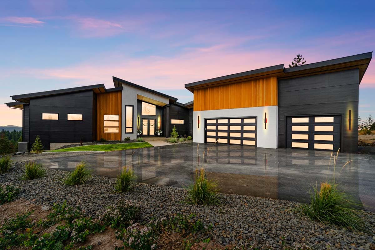 House plan exterior. Modern style with flat and angled rooflines. Features include wood siding, large windows, and a multi-car garage.