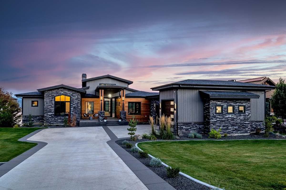 House plan exterior. Modern style, one story. Features include stacked stone accents, covered entry, and mixed rooflines.