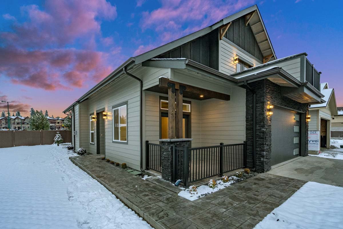 House plan exterior with modern farmhouse style, gable roof, covered porch with exposed beams, stone accents, and two-car garage.