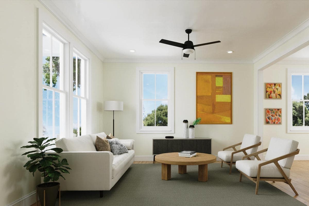 Living room with sofa, two chairs, coffee table, ceiling fan, and large windows.