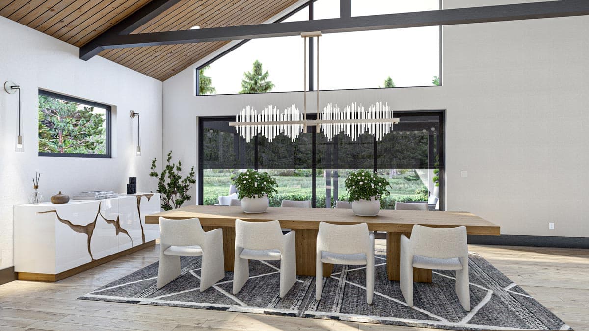 Modern dining room with a long wooden table, six chairs, and a unique chandelier. Large windows offer a view of trees outside.