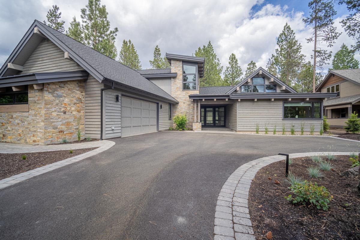 Modern house plan exterior with stone and horizontal siding, gabled roof, and two-car garage.