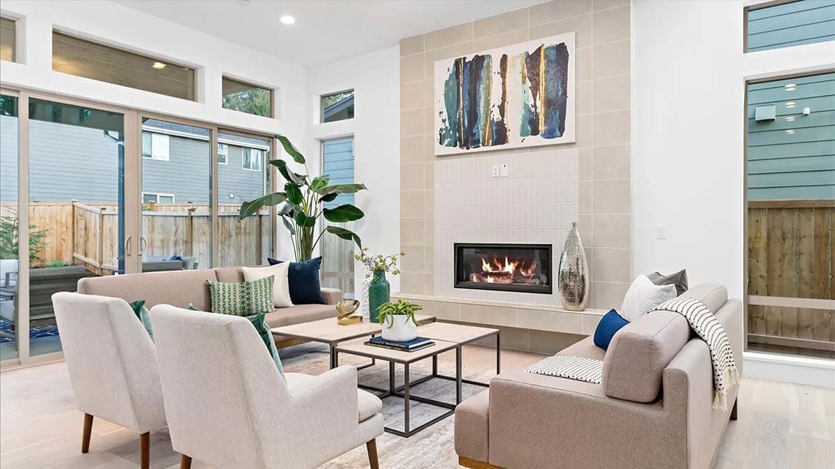 Living room with fireplace, tile surround, large sliding glass doors, and upper clerestory windows.