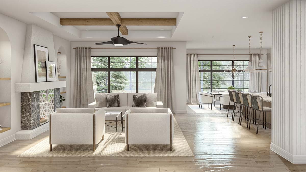 Open-concept living and dining area with a fireplace, beamed ceiling, kitchen island with bar stools, and large windows.