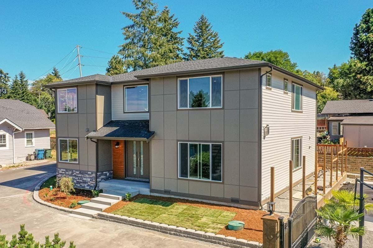 Two-story modern house plan exterior with gray panel siding, white horizontal siding, and a covered entry with wood accents.