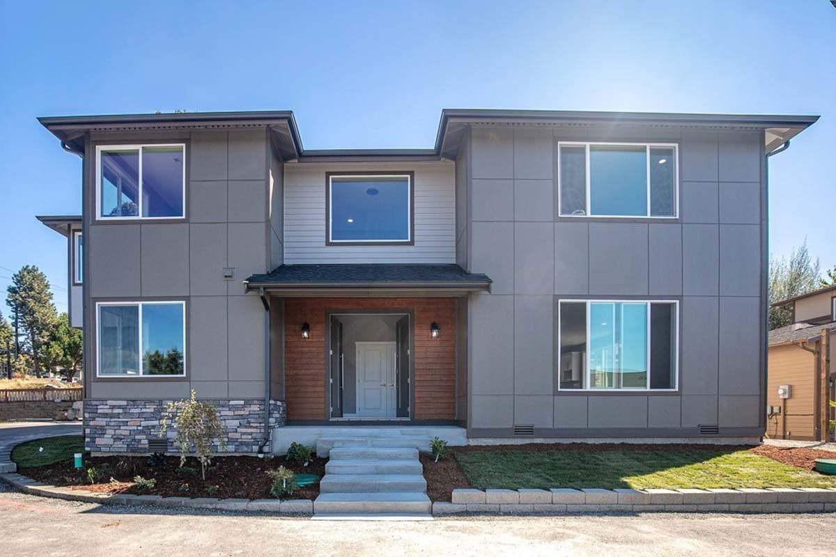 Modern two-story house plan exterior with stacked stone accents, flat roof, and wood-paneled entryway.
