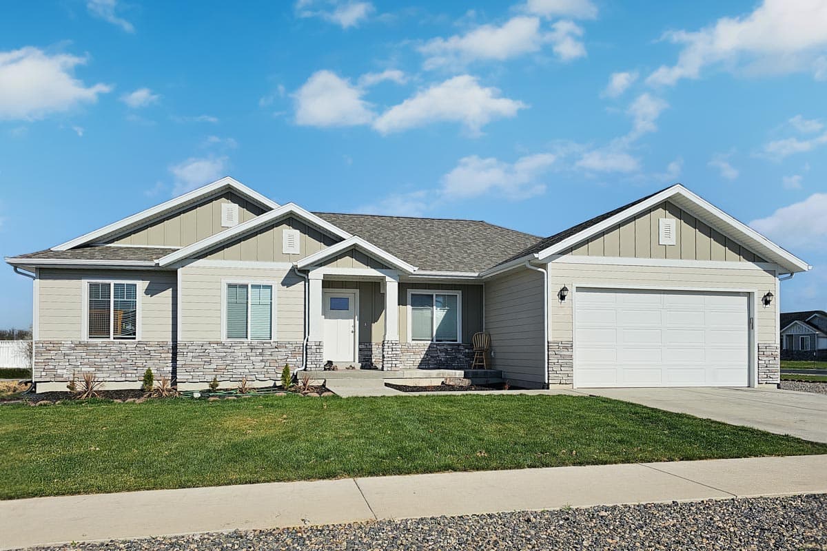 House plan exterior. Ranch style with a low-pitched roof, stone veneer accents, and a two-car garage. Features include gabled rooflines.