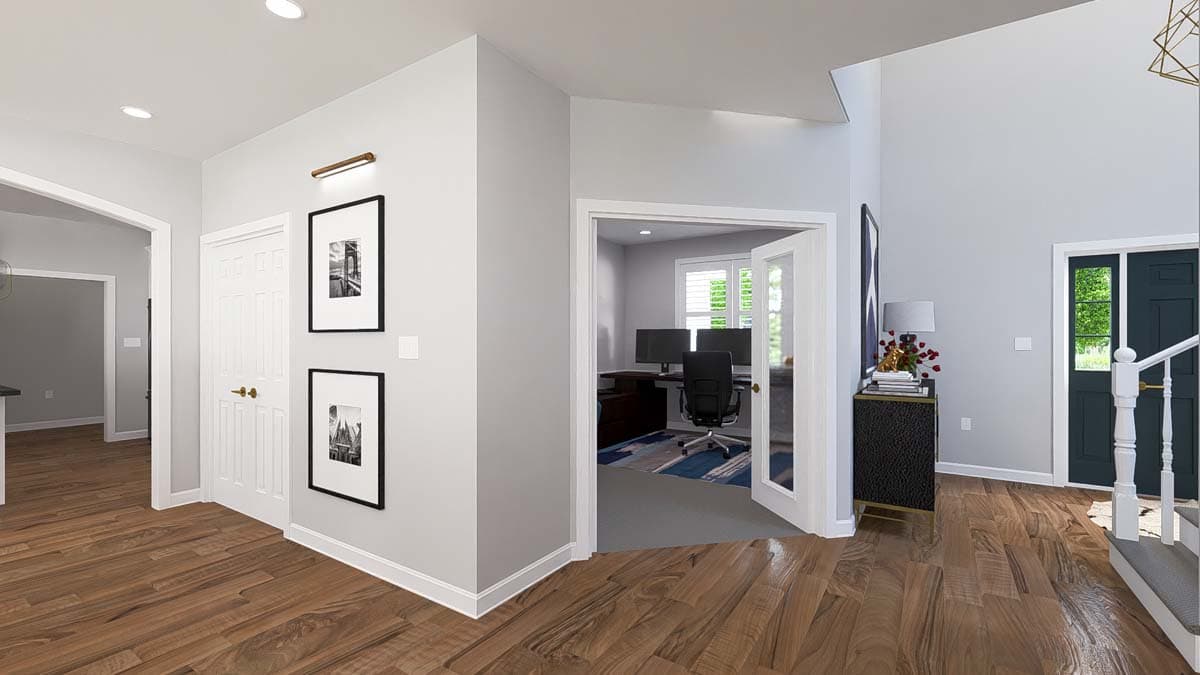 Interior view of a hallway with wood floors, a home office visible through glass doors, and a staircase.