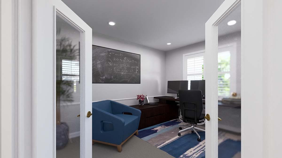Home office with desk, dual monitors, blue armchair, and chalkboard with equations.