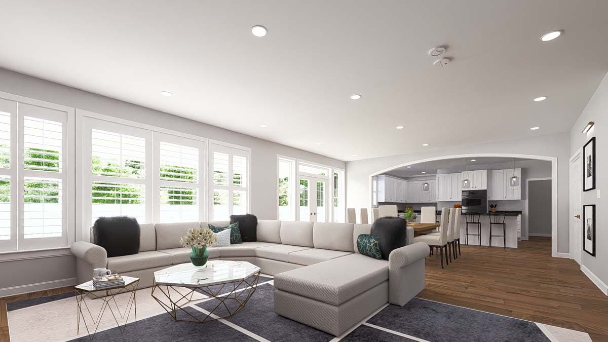 Open concept living area with large sectional sofa, sectional connects to dining area and kitchen with island and bar stools.