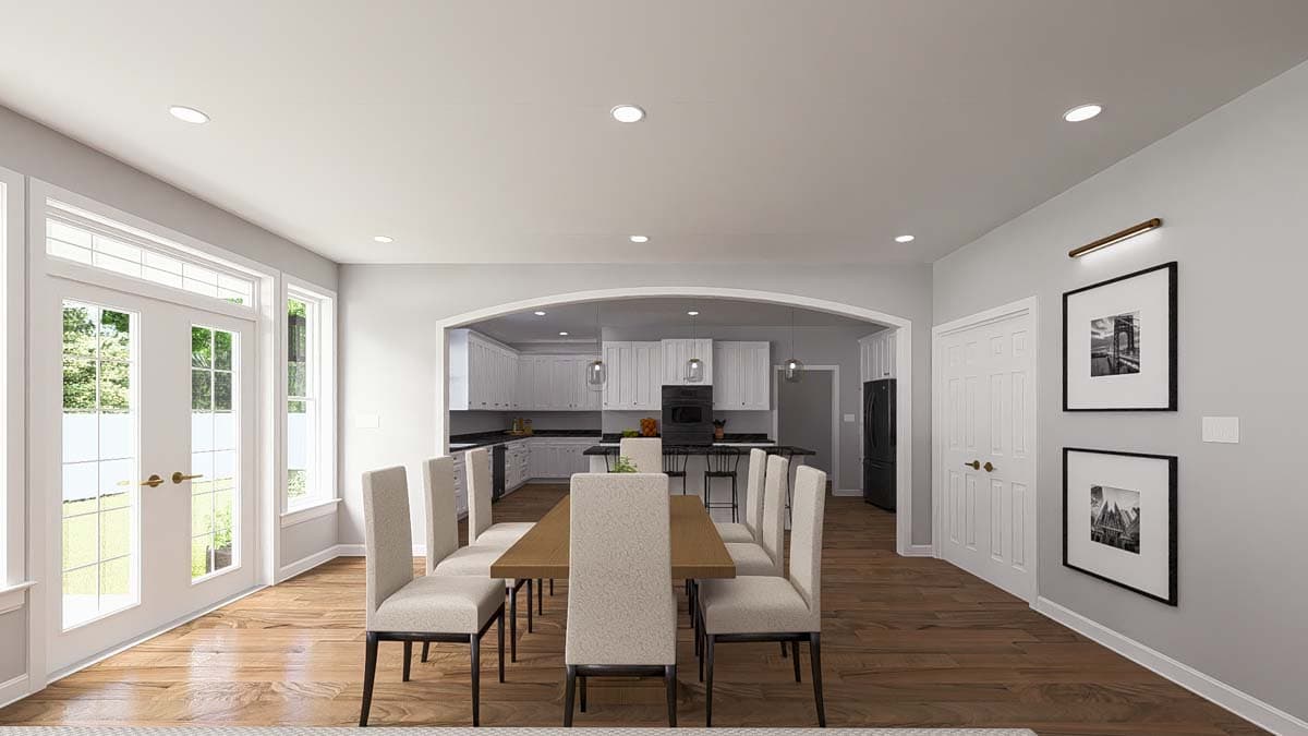Dining room with table for eight and arched opening to white kitchen with island and bar seating.