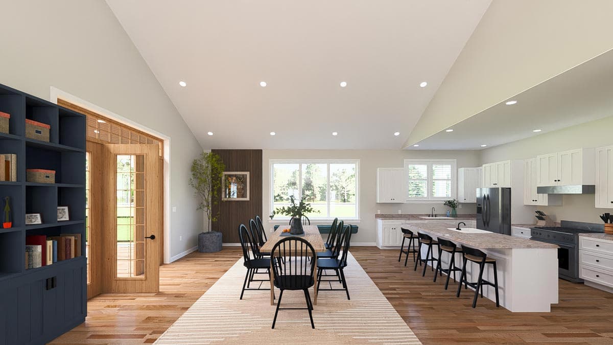 Open concept dining and kitchen with vaulted ceiling, large windows, island seating, and built-in shelving.