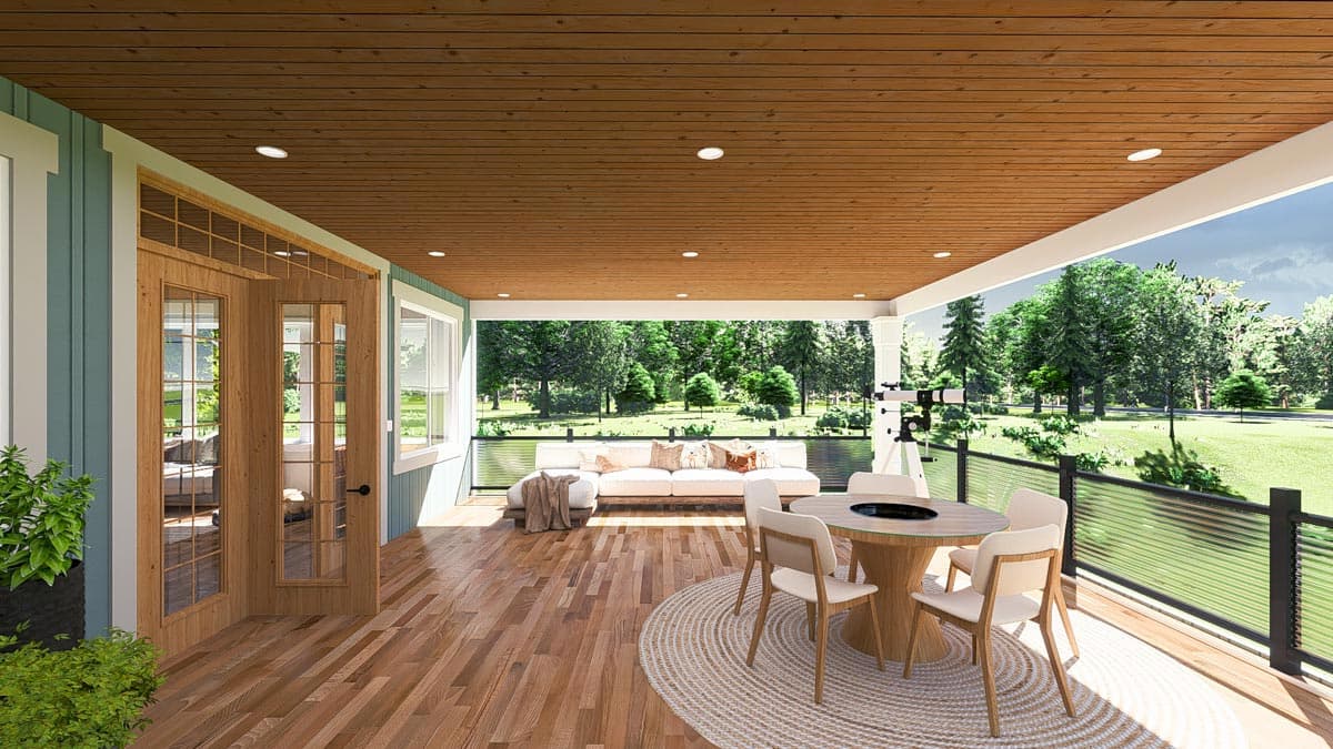 Covered porch with wood ceiling, glass doors, dining set, and outdoor seating overlooking a wooded backyard.