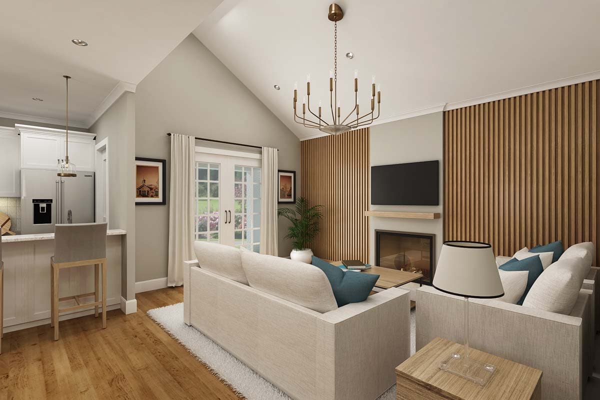 Open concept living area with vaulted ceiling, fireplace, kitchen island, and French doors.