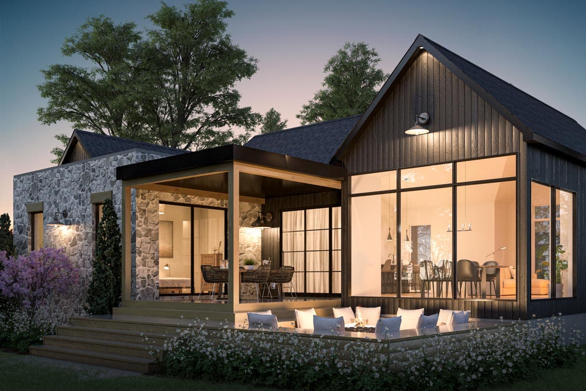 Modern house exterior at dusk with open-air dining area and fire pit. Large windows reveal a warm interior, illuminated by soft lighting.