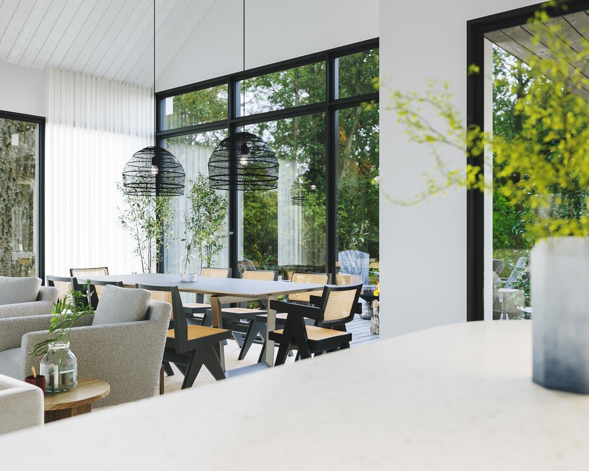 A modern dining room featuring a long table with black chairs, two hanging woven lamps, and large windows overlooking a lush green yard.