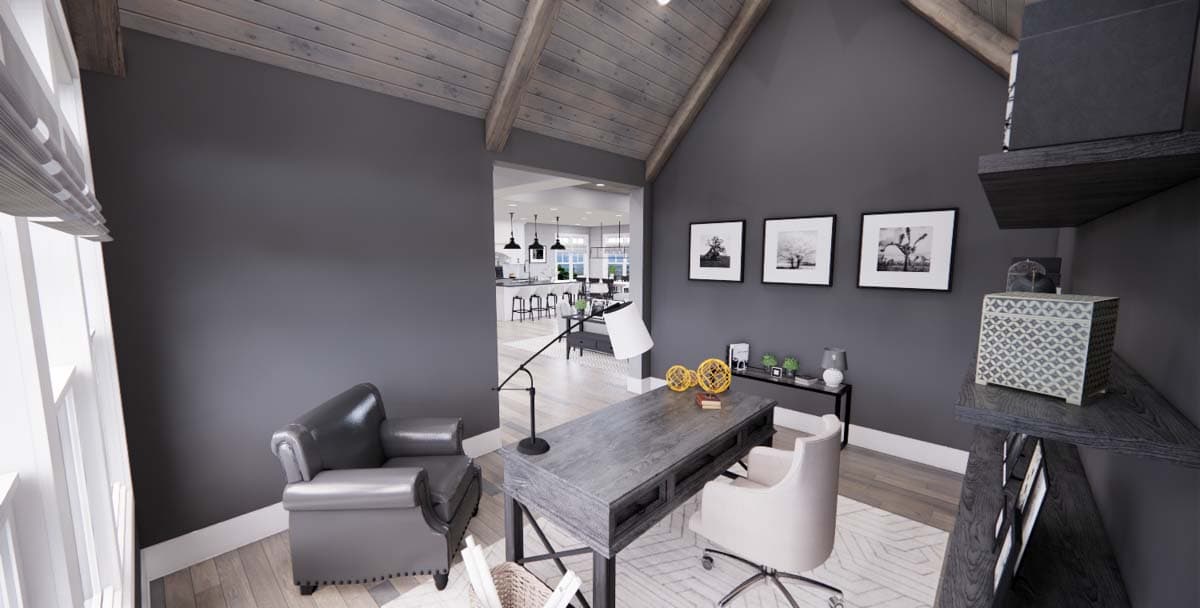 Interior view of a home office with vaulted wood-beamed ceiling, desk, chairs, and view into kitchen.