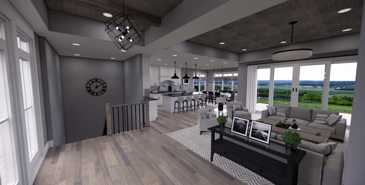 Open concept living area with kitchen island, dining area, and living room featuring vaulted ceilings and large windows.