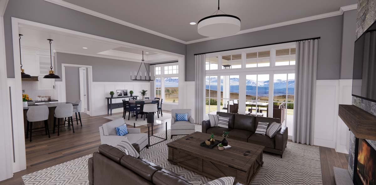 Open-concept living area with kitchen island, dining room, great room with fireplace, and large windows overlooking a mountain view.