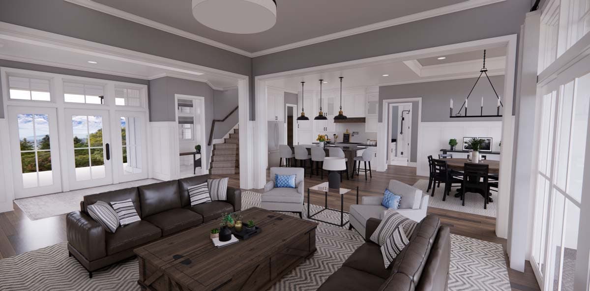 Great room with fireplace, kitchen island, and dining area. Staircase visible.
